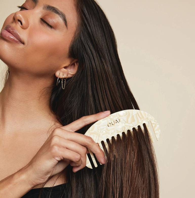 OUAI custom hair comb in use